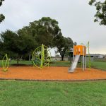 Playground equipment with steel slide in bright green and orange colours