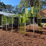 silver and bright lime green playground with spiral climber and monkey bars