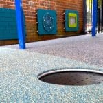 inground circular trampoline installed in rubber wetpour surfacing