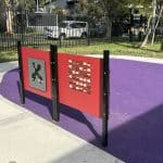Two interactive sensory panels with purple rubber surfacing and a concrete bike path