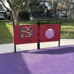 Two interactive sensory panels with purple rubber surfacing and a concrete bike path