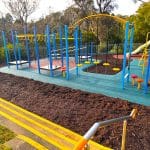 Old school playground with new rubber surfacing with bark mulch border