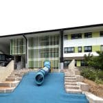 Blue tube embankment slide with blue rubber wetpour and sandstone logs tiered for steps