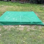 Above ground sandpit with green cover