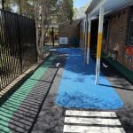 Black Rubber Wetpour bike track with pedestrian crossing and directional arrows.
