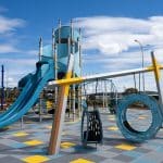 Silver architectural type frame with two large round blue tyre like swing pods
