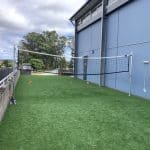 Synthetic Grass area with a volleyball net and two posts