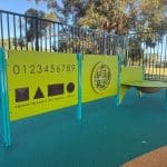 Three brightly coloured play panels mounted on blue posts.