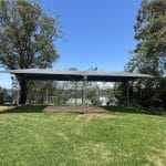 steel framed shade structure over sandpit area with charcoal coloured shade cloth canopy