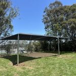 steel framed shade structure over sandpit area with charcoal coloured shade cloth canopy
